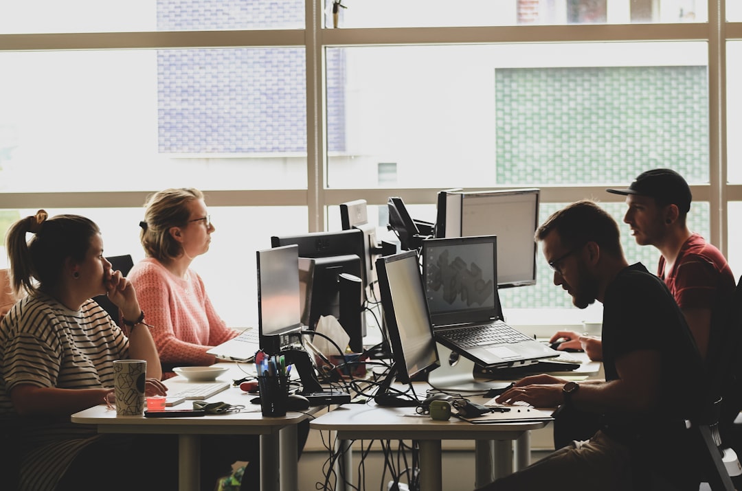 A diverse team working together on a web application project in a co-working space.